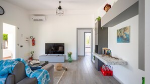 A modern living room with a TV, sofa, and a dining area with a marble countertop. - Holiday Home 'Dammar' with Mountain View, Wi-Fi and Air Conditioning (Tertenìa)