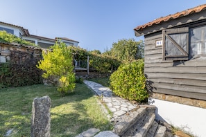 Un patio con un sendero de piedra que conduce a un edificio de madera con tejado de tejas.