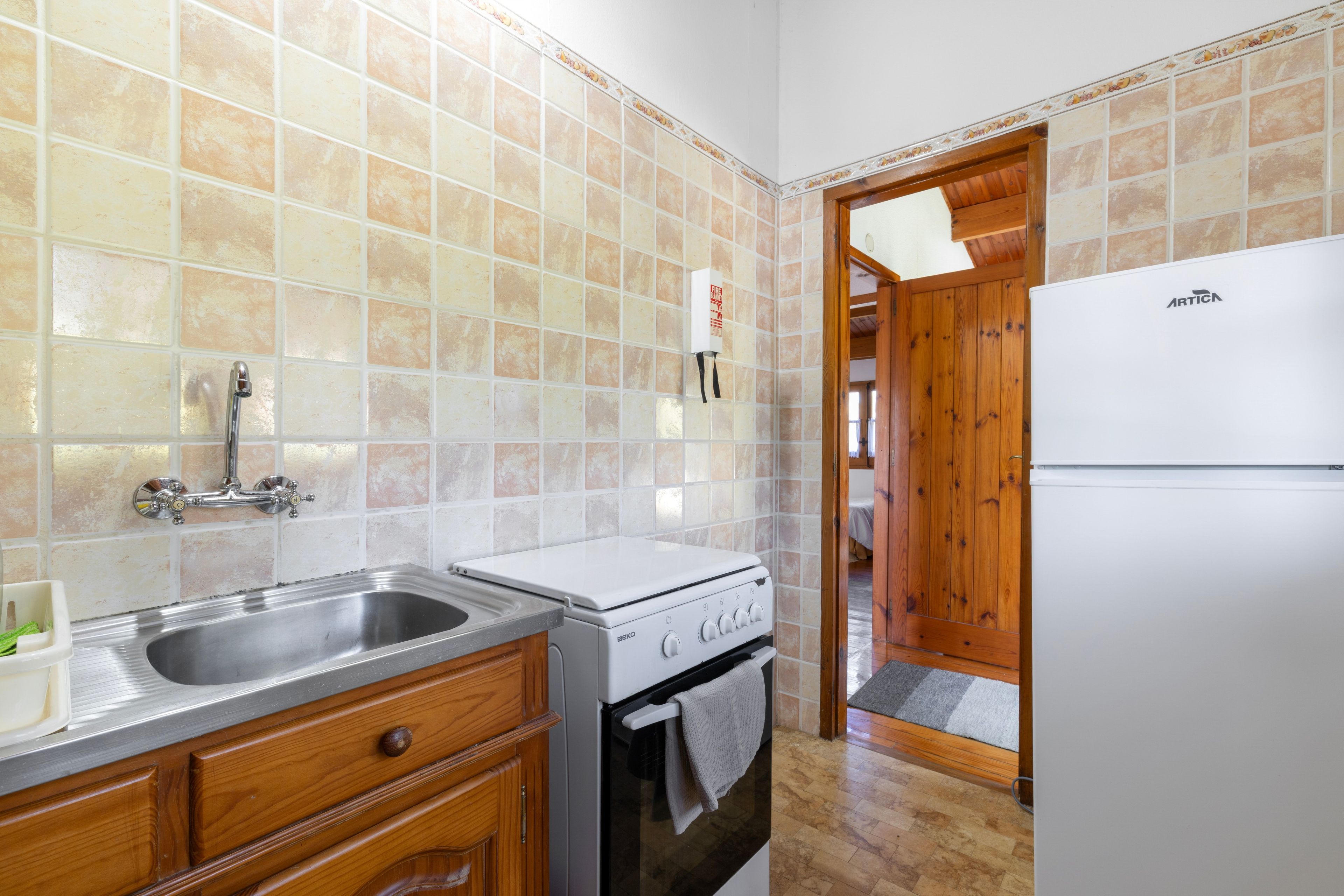 A kitchen with a sink, stove, and refrigerator.