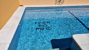 En swimmingpool med flisekant og et hjul-symbol på væggen.