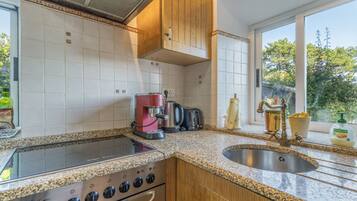 Una cocina con estufa, cafetera y tostadora.