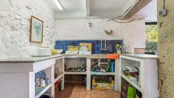A compact kitchen with white walls, blue tiles, and a tiled floor.