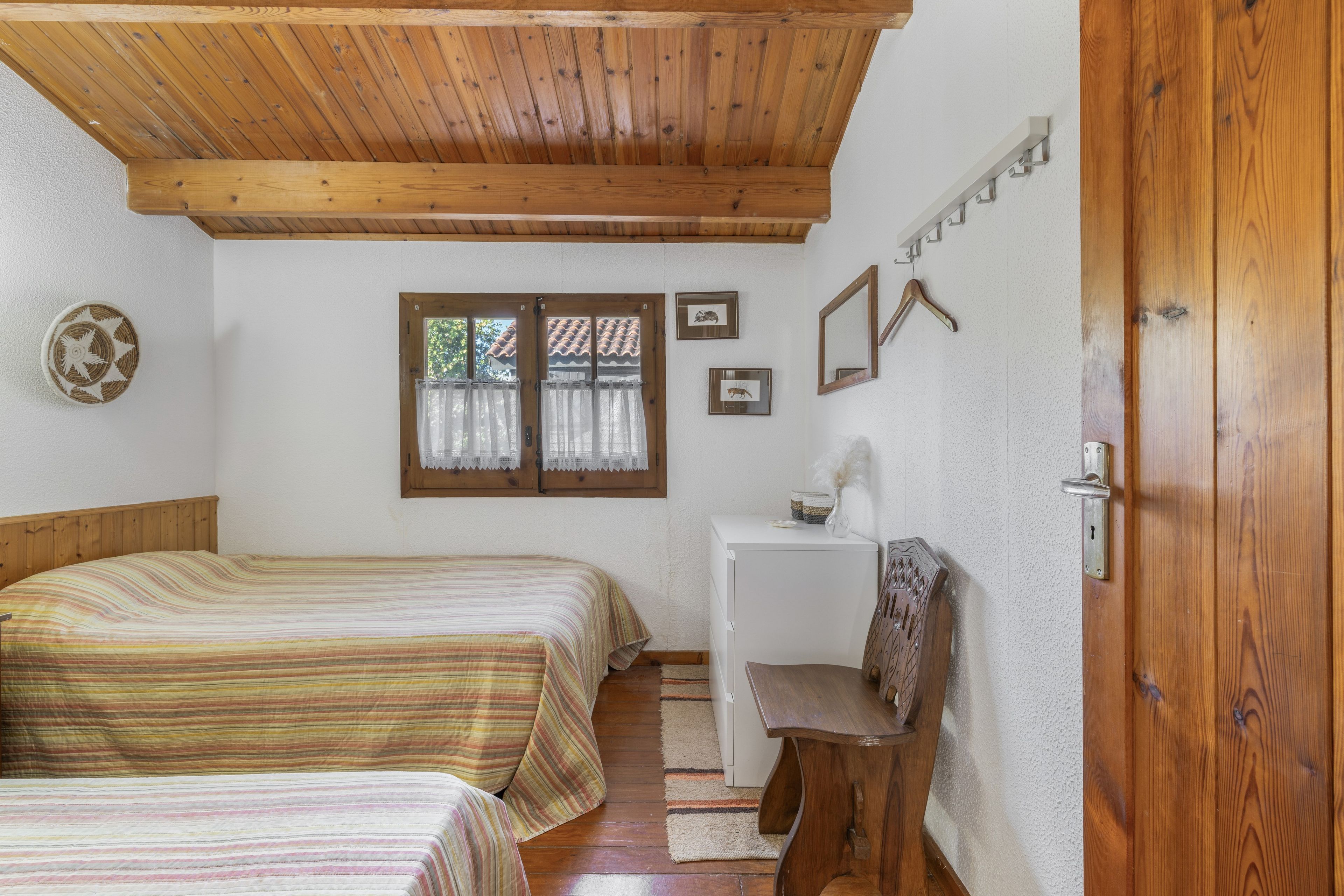 Une chambre avec deux lits, un bureau et une chaise.