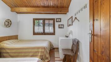 Un dormitorio con dos camas, un escritorio y una silla.