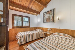 A room with two beds, wooden walls, a window with curtains, and a painting on the wall. - Apartment 'Rosal Lodge' with Mountain View, Shared Pool and Wi-Fi (As Eiras)