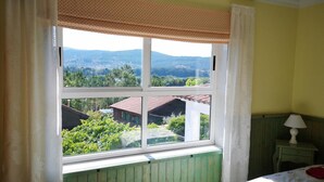 A bedroom with a large window, a bed, a nightstand, and a view of a green landscape. - Rural Complex 'Shakti Rio Mino' with Lake Views, Private Pool and Wi-Fi (Eiras)