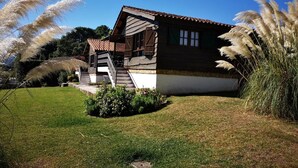 A traditional wooden house with a sloped roof, a staircase leading to a porch, and a well-maintained lawn. - Rural Complex 'Shakti Rio Mino' with Lake Views, Private Pool and Wi-Fi (Eiras)
