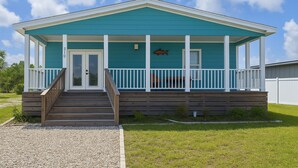A single-story house with a porch, a front door, and a small fish decoration.