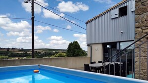 Piscina con vista a un edificio de piedra y un paisaje.