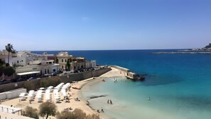 Una località costiera con spiaggia, passeggiata e edifici lungo il lungomare.