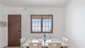 A dining area with a table, chairs, a window, and a door.