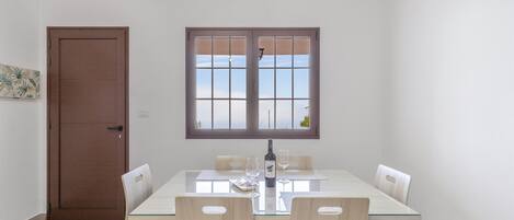Un comedor con una mesa, sillas, una ventana y una puerta.