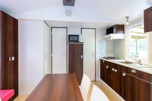 A compact kitchen with a central island, built-in microwave, and a stove.