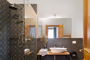 A bathroom with a shower, a sink, and a mirror.