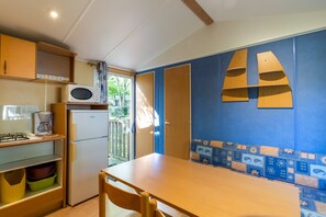 Eine kleine Küche mit Mikrowelle, Kaffeemaschine und Kühlschrank.