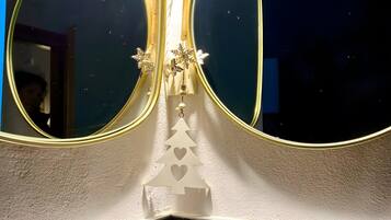 Un coin agrémenté de deux grands miroirs, d’un sapin de Noël décoratif et d’un mur à texture.