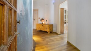 A hallway with wooden flooring, a wooden cabinet, and a wall with a painted forest scene. - Room 'Con Sauna 2' with Mountain View and Wi-Fi (Castello Tesino)