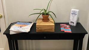 A reception desk with a welcome sign, a potted plant, brochures, and a map.