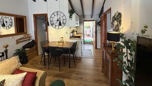 A spacious living area with a dining table, chairs, a sofa, and a kitchen in the background. - Casa Trinidad – private terrace, parking, historic center of Dénia (Dénia)