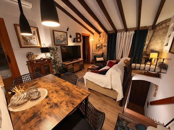 Un salon chaleureux avec une table à manger en bois, un canapé confortable et un téléviseur.