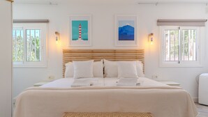 A bed with a wooden headboard, white bedding, and two wall-mounted light fixtures. - Vacation 'Colina Blanca Sunset View' with Sea View, Shared Pool and Wi-Fi (Costa Adeje)