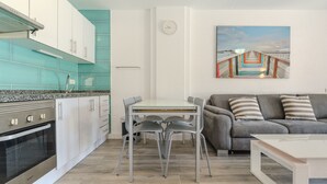 A modern kitchen with white cabinets, a stainless steel oven, and a teal backsplash. - Vacation 'Colina Blanca Sunset View' with Sea View, Shared Pool and Wi-Fi (Costa Adeje)