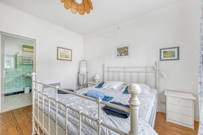 A bedroom with a bed, bedside table, and a mirror. - Escapade au Lac – Comfortable House with Garden in Lacanau (Lacanau)