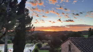 A rural landscape with a clear sky, a large tree, and a building with a tiled roof. - Clémentine Room – Romance & Comfort – Shared Pool (Proissans)