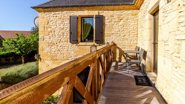 A stone building with a wooden deck, a window with shutters, and a door. - Clémentine Room – Romance & Comfort – Shared Pool (Proissans)