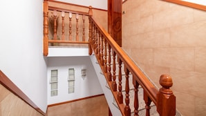 A wooden staircase with a handrail, a door at the top, and a wall with a light fixture. - Holiday Home 'El Atico' with Sea Views, Private Terrace and Wi-Fi (Las Palmas)