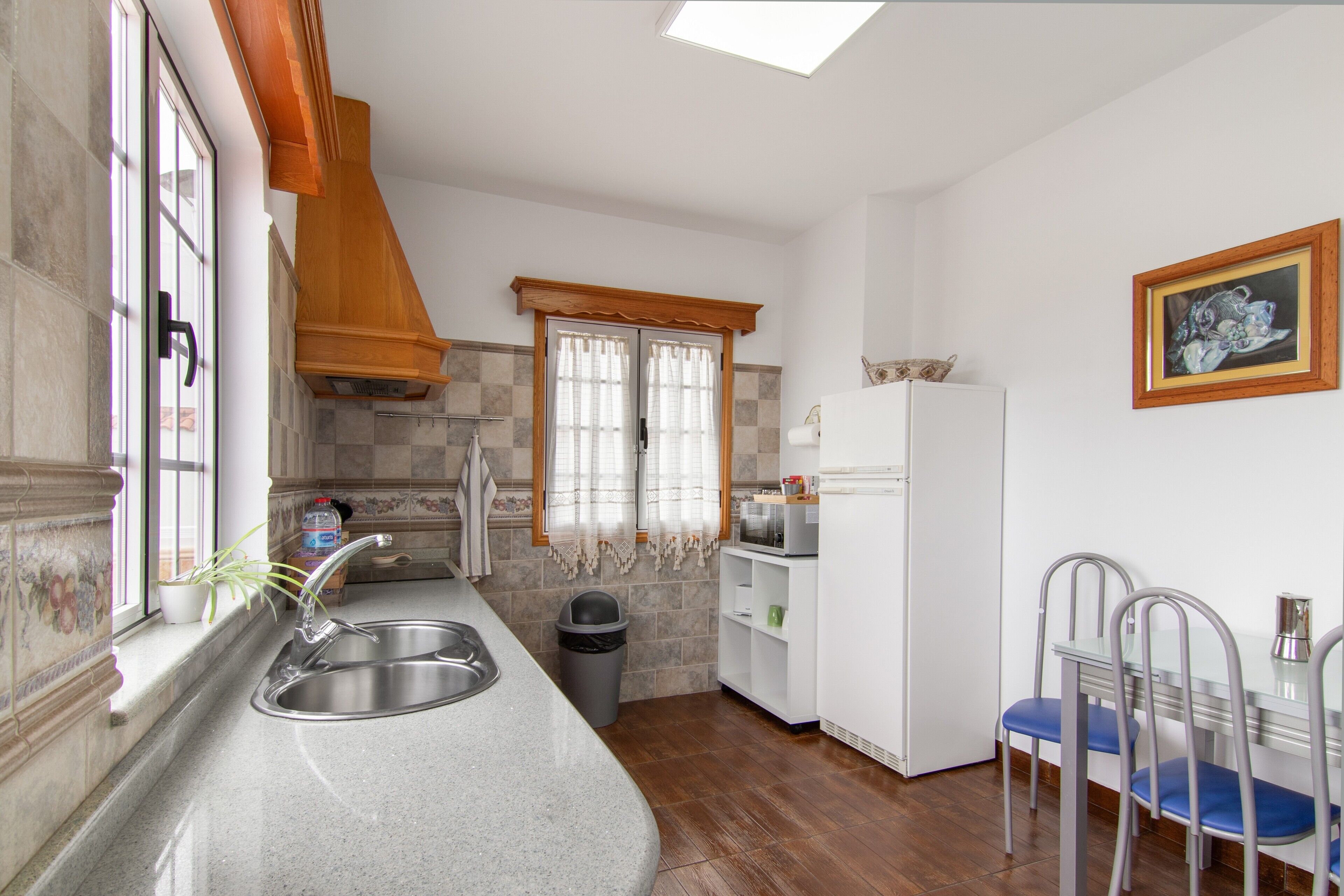 Una cocina con un lavamanos, un microondas y un refrigerador.