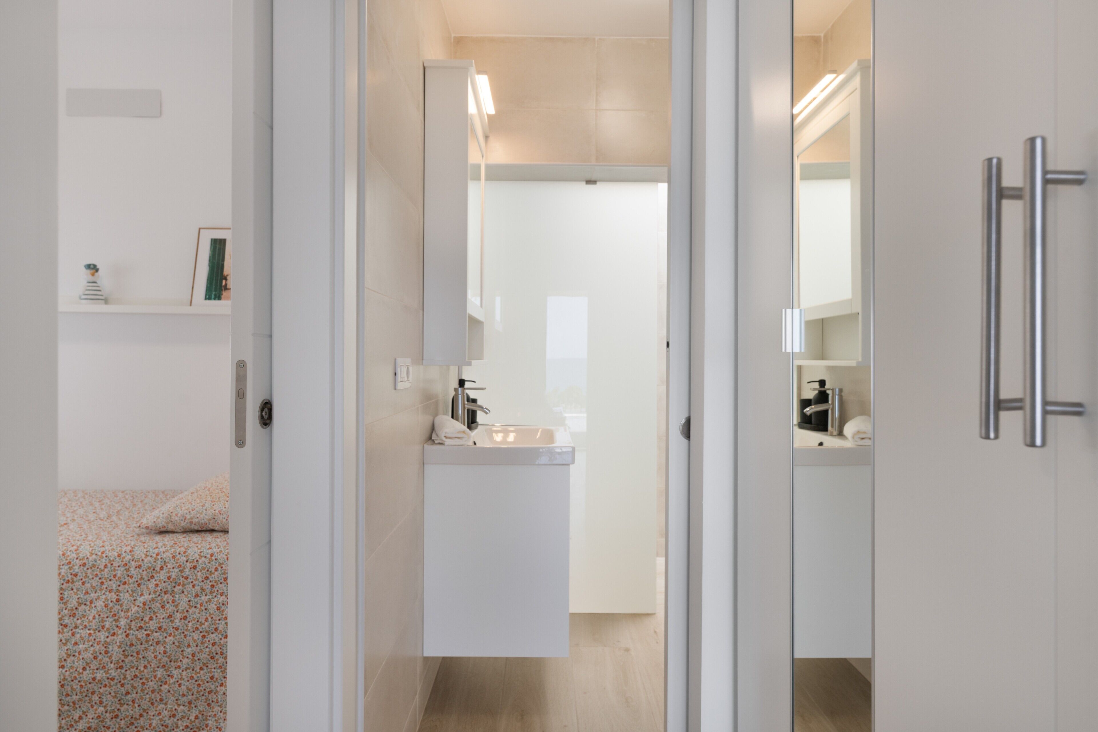 Une salle de bain moderne avec un lavabo, un miroir et un porte-serviettes.