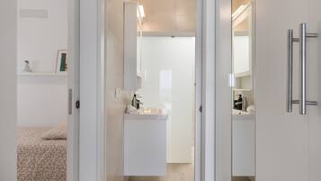 Une salle de bain moderne avec un lavabo, un miroir et un porte-serviettes.