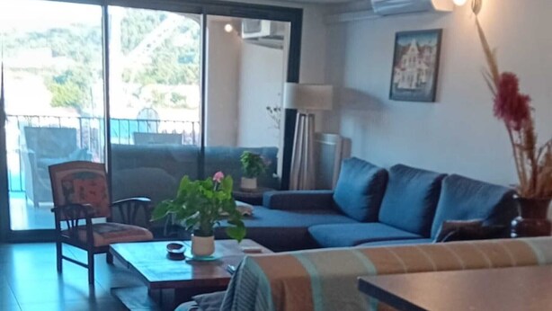 A living room with a sofa, coffee table, and a dining table with chairs.