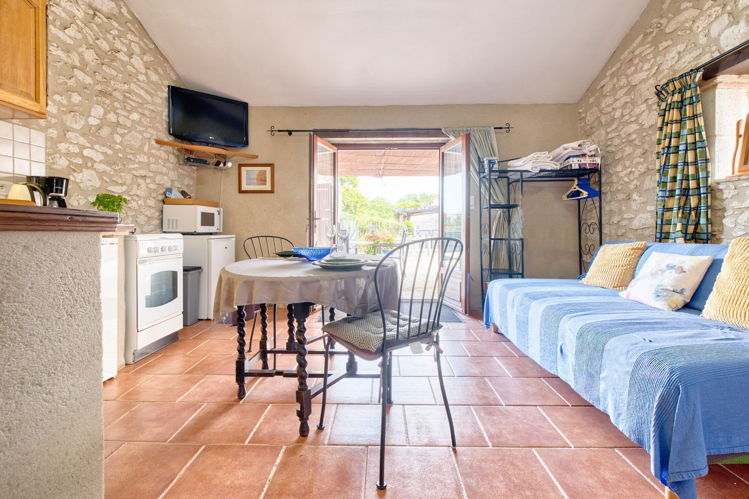 Habitación compacta con cocina, comedor y cama.