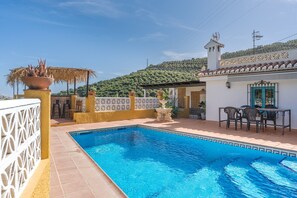 A swimming pool with a tiled edge, a white fence, and a patio area with chairs and a table. - Holiday Home 'Adelfas' with Sea View, Wi-Fi and Air Conditioning (Granada)