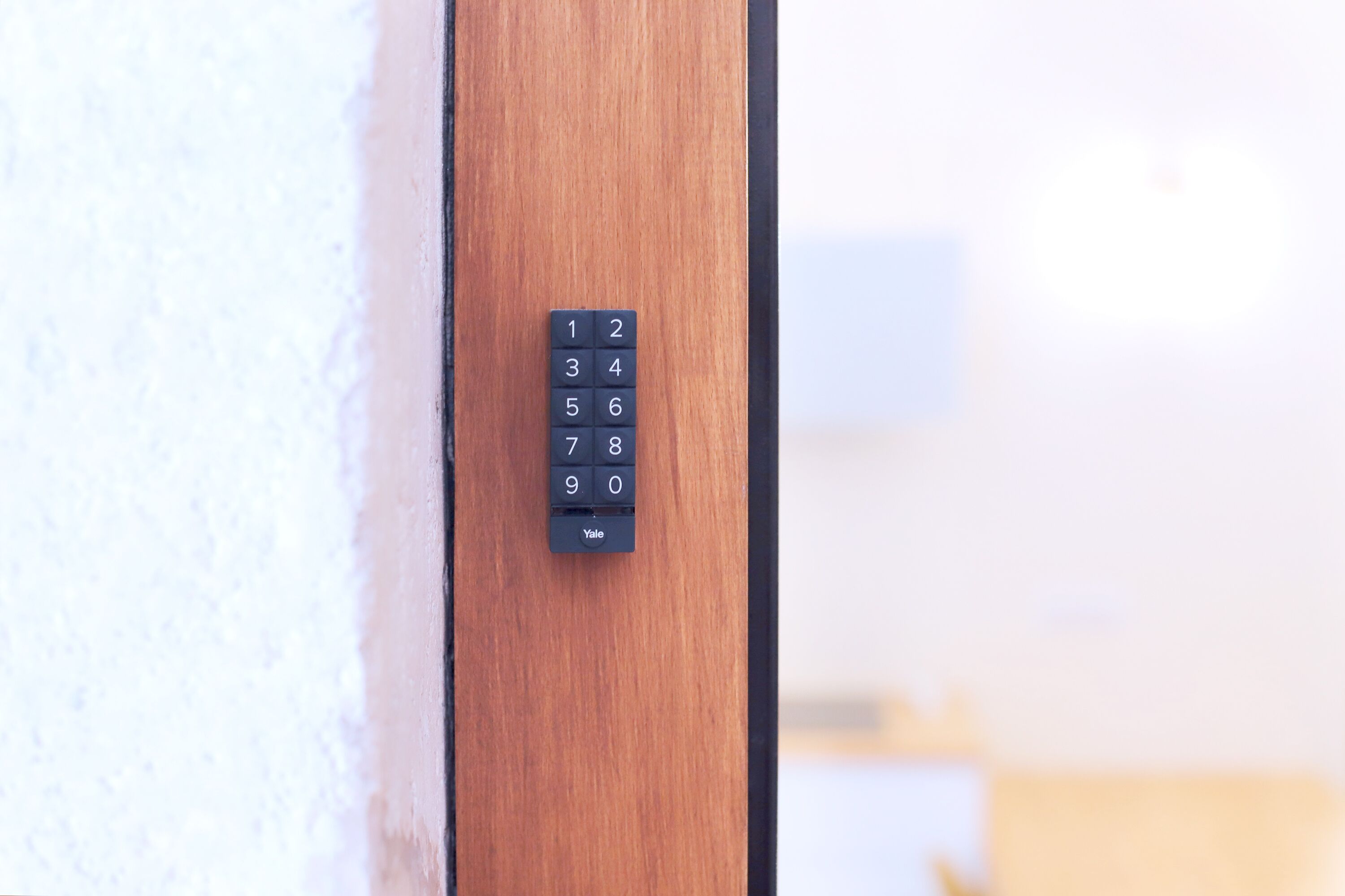 A keypad lock on a wooden door.