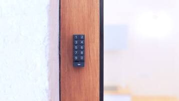 A keypad lock on a wooden door.