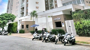 A high-rise residential building with multiple balconies and a gated entrance.