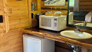 Eine kleine Küche mit Kühlschrank, Mikrowelle, Spüle und einem Heizgerät.