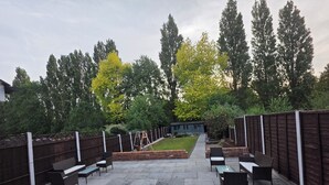 A patio area with stone flooring and outdoor furniture.