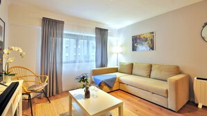 Una sala de estar moderna con un sofá, una mesa de centro, una silla y una lámpara.