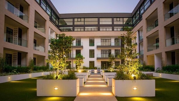 Un edificio moderno con un cortile centrale, circondato da balconi e ampie finestre.