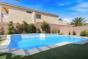 A swimming pool with a house in the background.