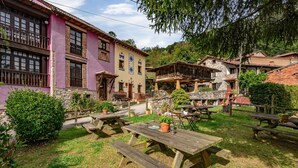 Een binnentuin met picknicktafels en potplanten, omgeven door gebouwen met traditionele architectuur.