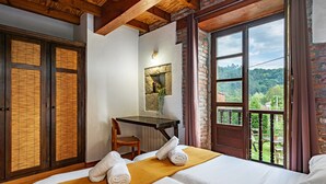 Une chambre d’hôtel avec un lit, un bureau, une chaise et une vue sur l’extérieur.