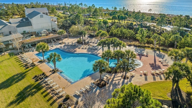 A resort with a large pool, lounge areas, and a view of the ocean. - Falling Star Retreat is a 4BA/2BA coastal home, just 900 feet to the beach, pet friendly! (Port St. Joe)