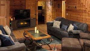 A spacious wooden cabin with a balcony, a large TV, and a cozy seating area with a coffee table. - Bachelor Parties, direct access to Lehigh River to hike, bike, fish and swim. (White Haven)