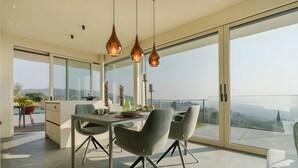 A modern dining area with a large table, chairs, and pendant lights. - Villa 'Vallonga' with Lake View, Wi-Fi and Air Conditioning (Bardolino)