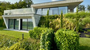 A modern house with a flat roof, large windows, and a well-maintained garden. - Villa 'Vallonga' with Lake View, Wi-Fi and Air Conditioning (Bardolino)